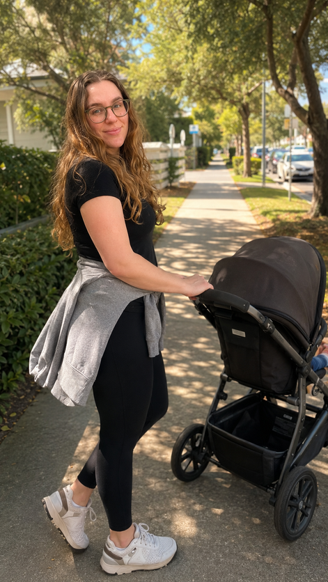 Danielle out for a walk pushing a stroller on a tree-lined street